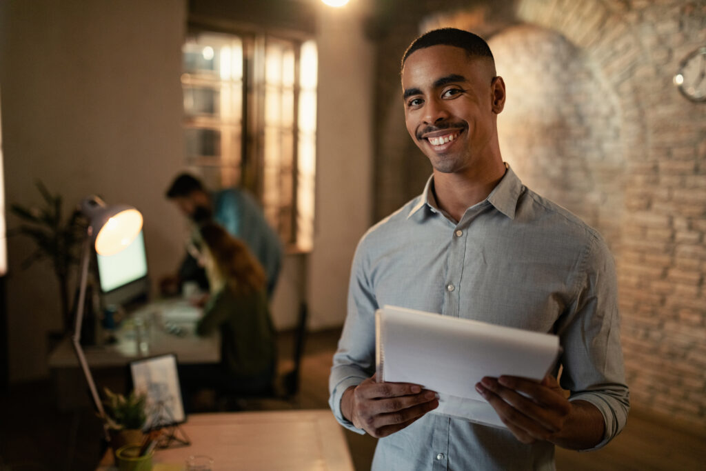 Portrait of happy African American entrepreneur working at night